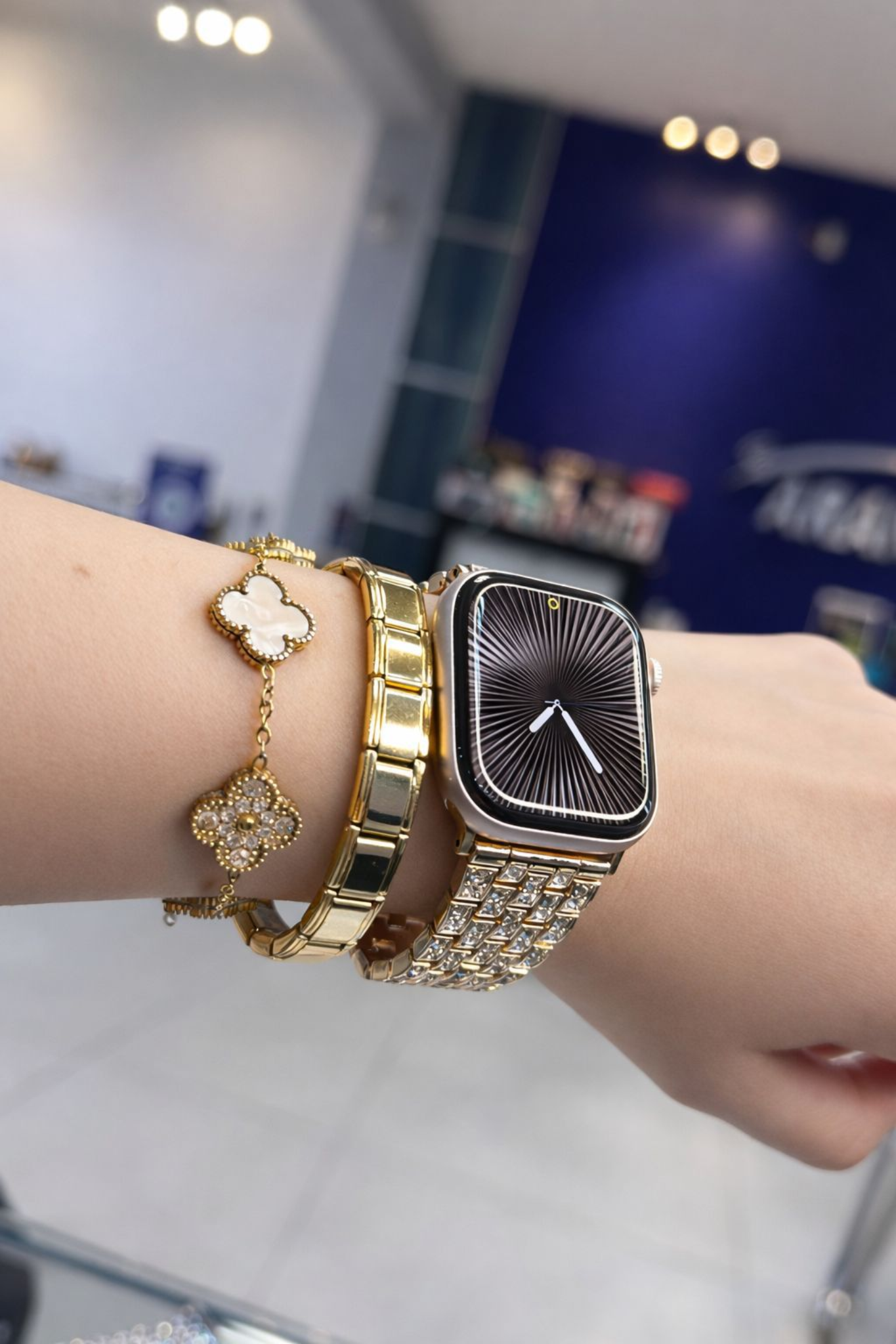 iPhone Pro dorado en mano con pulsera